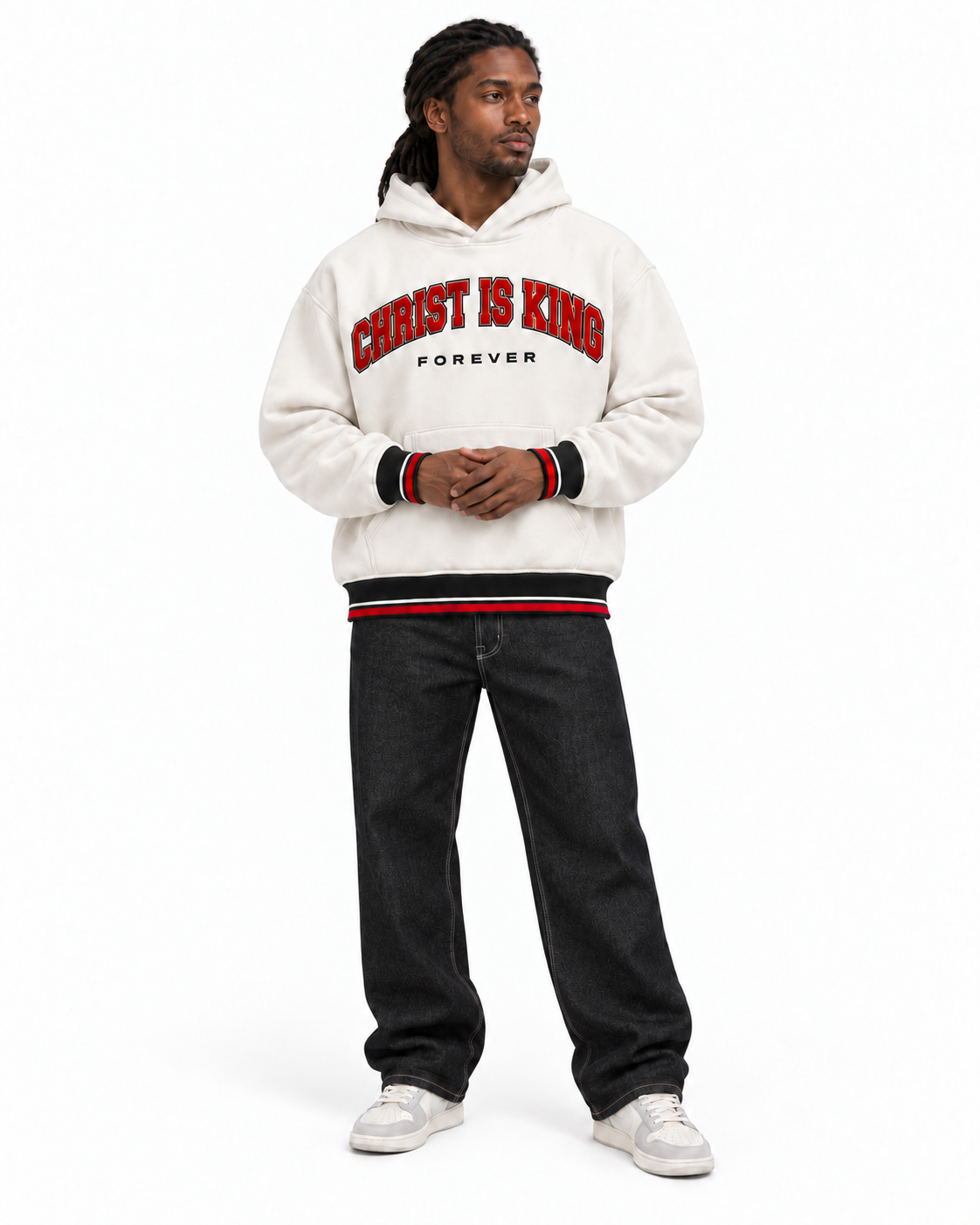 Full-body front view of a model wearing the white CHRIST IS KING FOREVER Varsity Hoodie with black jeans and gray-and-white sneakers.